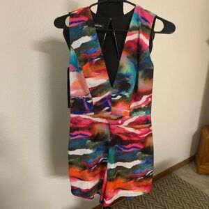 Cute Bebe romper. Multi color with cutout back.